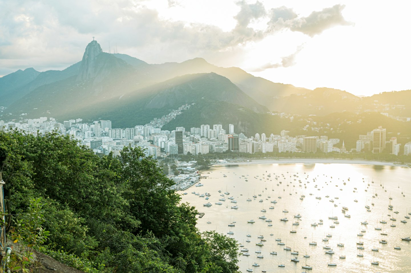 Coastal city with boats in the bay and Christ the Redeemer statue.